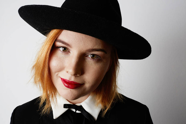 Close-up portrait of hipster girl wearing black dress and hat. Isolated. - Фото, зображення