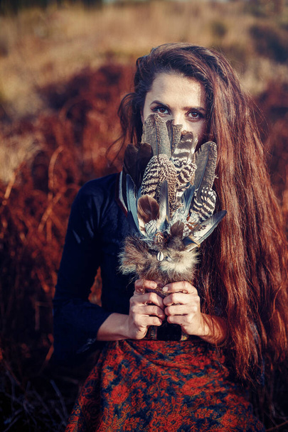 Šamanská žena a šamanské peří na džínsu. - Fotografie, Obrázek