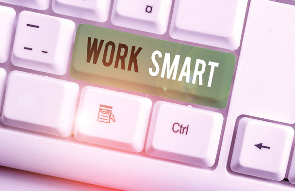 Pisanie notatki pokazującej Work Smart. Biznesowe zdjęcie pokazujące, jak osiągnąć cele w najbardziej efektywny sposób Biała klawiatura PC z notatką na białym tle. - Zdjęcie, obraz