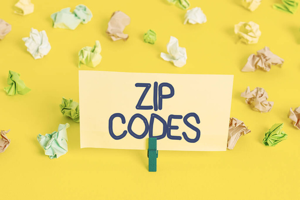 Zip Codes 'u yazan el yazısı. Postaların sıralanmasına yardımcı olmak için posta adresine eklenen sayıların anlamını kavra Renkli buruşmuş kağıtlar boş hatırlatıcı beyaz zemin çamaşır mandalı. - Fotoğraf, Görsel
