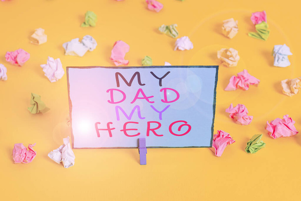Text sign showing My Dad My Hero. Conceptual photo Admiration for your father love feelings emotions compliment Colored crumpled papers empty reminder white floor background clothespin. - Photo, Image