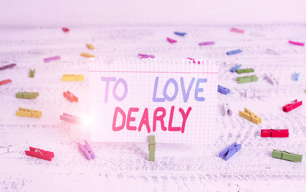 Handwriting text writing To Love Dearly. Concept meaning Love someone very much in the more humble way and aimlessly Green clothespin white wood background colored paper reminder office supply. - Fotoğraf, Görsel