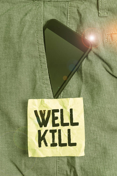 Pismo pisma "Well Kill". Koncepcja oznacza operację umieszczania kolumny ciężkiego płynu w dobrze zanurzonym urządzeniu Smartphone wewnątrz formalnej kieszeni spodni roboczych przedniej kieszeni w pobliżu papieru notatkowego. - Zdjęcie, obraz