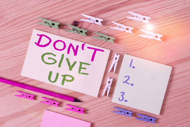 Text sign showing Don T Give Up. Conceptual photo Determined Persevering Continue to Believe in Yourself Colored clothespin papers empty reminder wooden floor background office. - 写真・画像