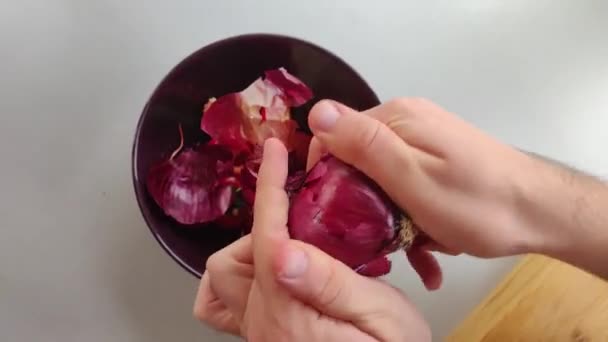 αρσενικά χέρια ξεφλούδισμα κρεμμύδι, σπιτικό φαγητό - Πλάνα, βίντεο