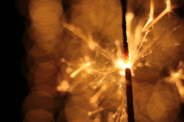 festive christmas background bokeh garland and sparkling sparkler - Photo, Image