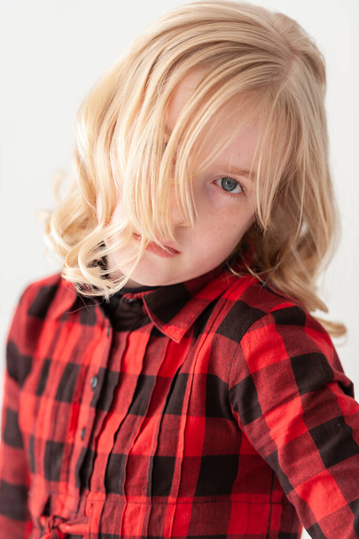 Hermosa joven rubia preadolescente chica con el pelo cubriendo un ojo en un fondo de estudio blanco
 - Foto, imagen