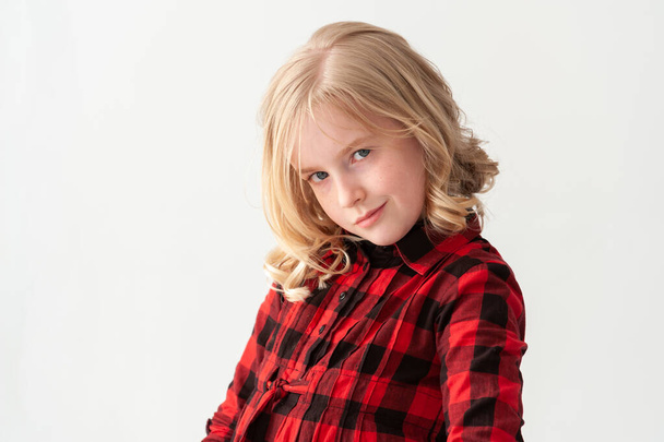 Medium shot of a beautiful young blonde preteen girl with attitude on a white studio background - Photo, Image