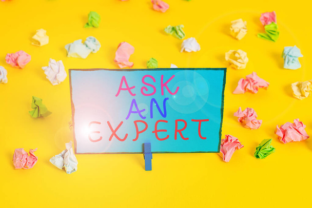 Text sign showing Ask An Expert. Conceptual photo Superior Reliable Ace Virtuoso Curapp storeity Authority Geek Colored crumpled papers empty reminder white floor background clothespin. - 写真・画像