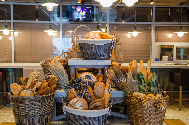 Корзина с большим количеством разнообразного хлеба
 - Фото, изображение