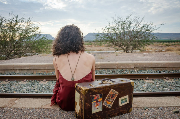 Femme de derrière assise sur la voie ferrée
 - Photo, image