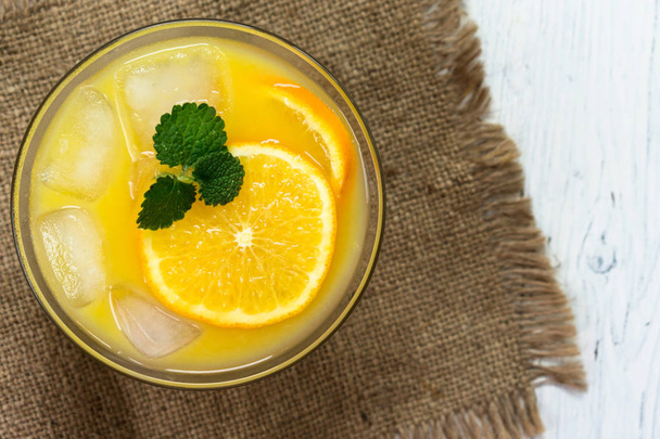 Glass of orange juice with ice and mint. Top view. - Foto, Bild