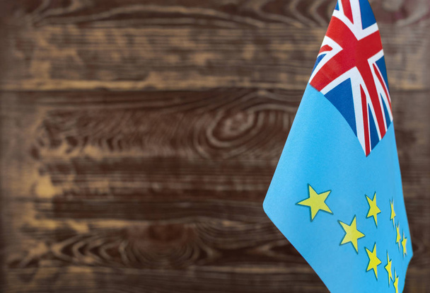 Fragment of the flag of Tuvalu Islands in the foreground blurred wooden background Kopi space - Valokuva, kuva