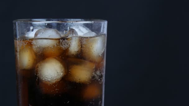 Kuplia kylmää colaa läpinäkyvä pitkä lasi jää mustalla taustalla lähikuva
. - Materiaali, video