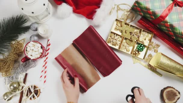 Nő vágás piros papírt csomagolására karácsonyi ajándékok - Felvétel, videó