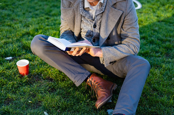 Jonge mannelijke hipster met retro fiets lees boek in het najaar park - Foto, afbeelding