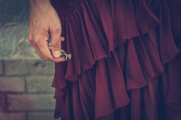 Frauenzeiger im roten Kleid hält eine Uhr - Foto, Bild