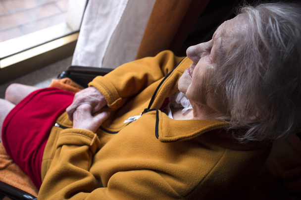 стара жінка дивиться у вікно
 - Фото, зображення