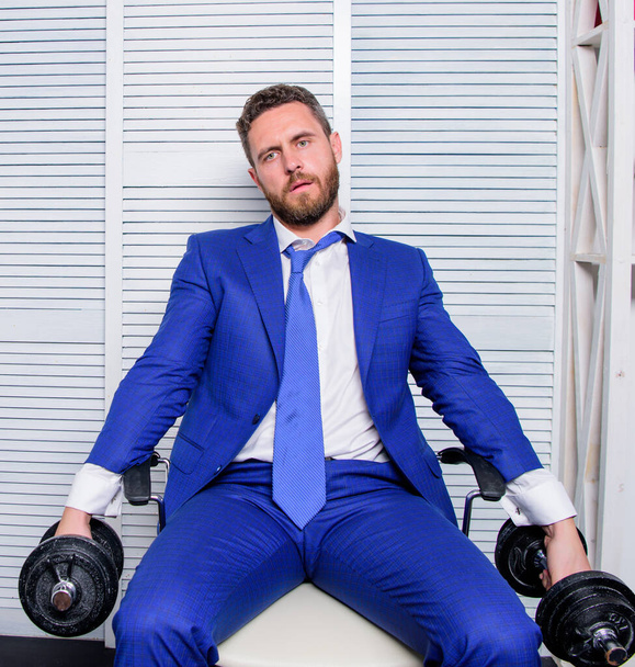 tired man working hard. should work for success. challenging himself. businessman hold dumbbell. sport and business. being best. overworker boss. time to relax. Strong powerful business strategy - Foto, imagen
