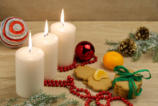 drei brennende Kerzen mit Weihnachtsdekoration. Weihnachtskomposition. - Foto, Bild