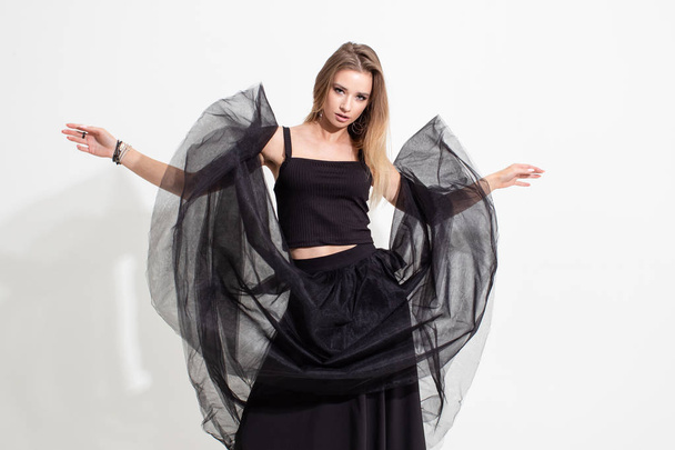 Girl in t-shirt and black skirt which soars in the air. Fashion shooting - Zdjęcie, obraz