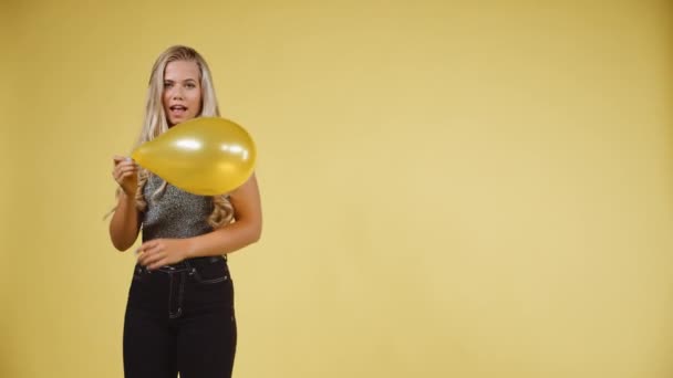 Attractive Young Blonde Dancing Seductively While Holding a Yellow Ballon - Felvétel, videó