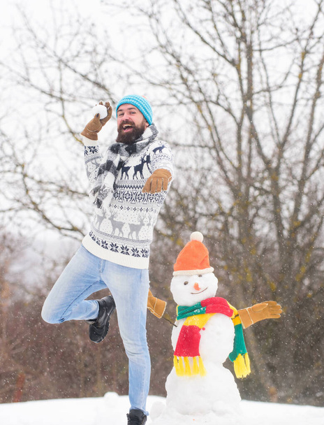 Be happy. happy hipster ready for xmas. winter season. Merry christmas. winter holiday. warm sweater in cold weather. man having fun. bearded man build snowman. Happy new year - Фото, зображення