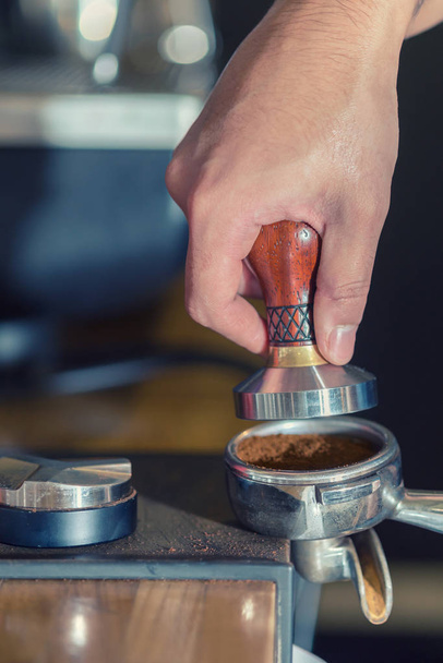 Pressing ground coffee tamper making espresso closeup. - Zdjęcie, obraz