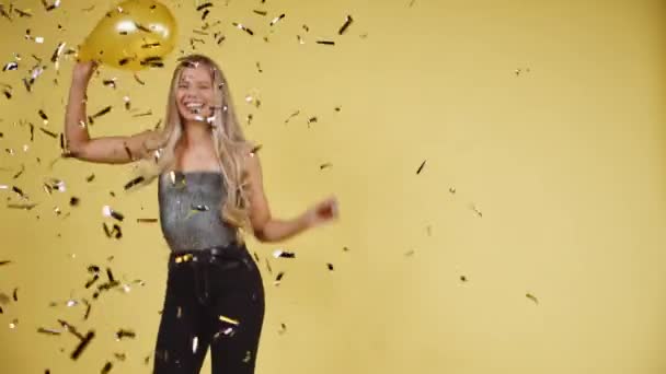 Mujer alegre bailando con sus manos ondeando en el aire con ráfaga de confeti
 - Imágenes, Vídeo