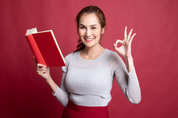 Jeune asiatique femme montrer OK avec un livre
. - Photo, image