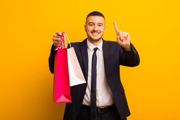 young handsome businessman  against flat background with shopping bags - Φωτογραφία, εικόνα