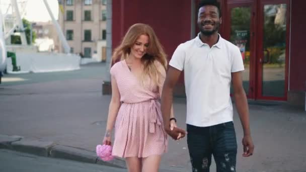 Happy couple in love walking on a pedestrian crossing holding hands - Video