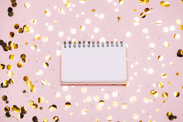 Empty note pad on pastel pink confetti background. - Photo, image