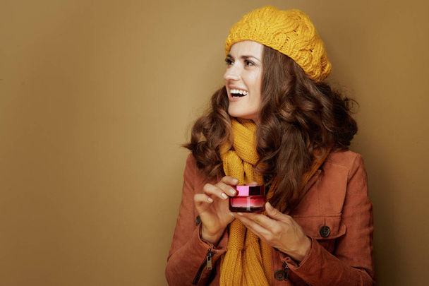 smiling woman with jar of facial creme looking at copy space - Foto, Imagem