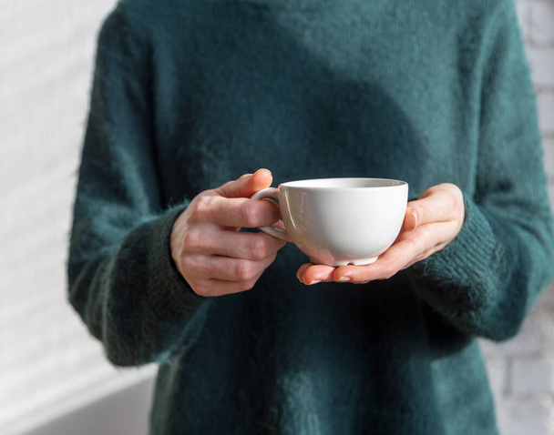 Tea or coffee cup in women's hands - Fotó, kép
