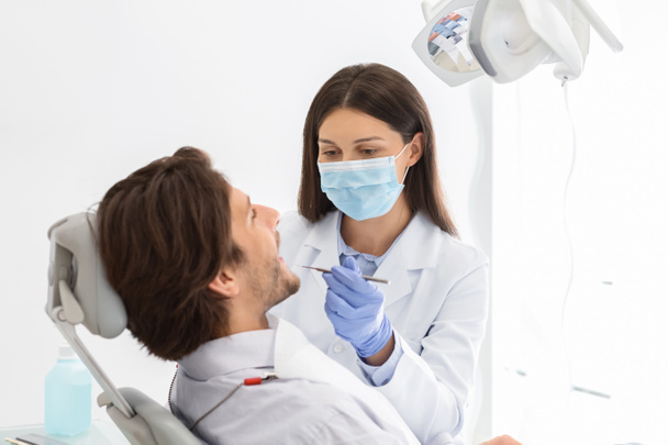Dentista femminile fare check up per il paziente maschile
 - Foto, immagini