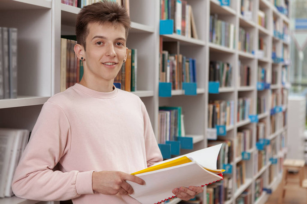 Młody człowiek w bibliotece lub księgarni - Zdjęcie, obraz