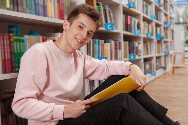 Young man at the library or bookstore - Photo, Image