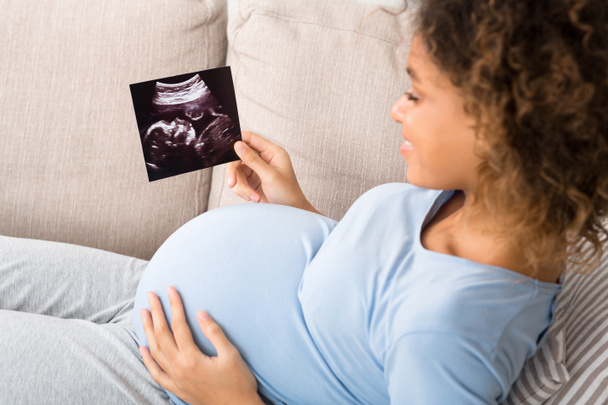 Afroamerykanka w ciąży przeprowadzająca USG w domu - Zdjęcie, obraz