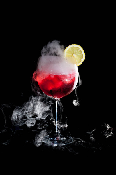 Kuru buz dumanı ve limon dilimi ile kırmızı soğuk kokteyl bir fincan - Fotoğraf, Görsel