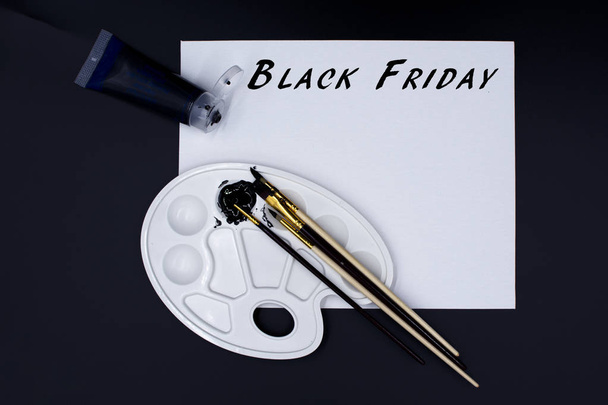 Paleta de pintura acrílica negra, pinceles y lienzo con el texto "Black Friday
" - Foto, imagen