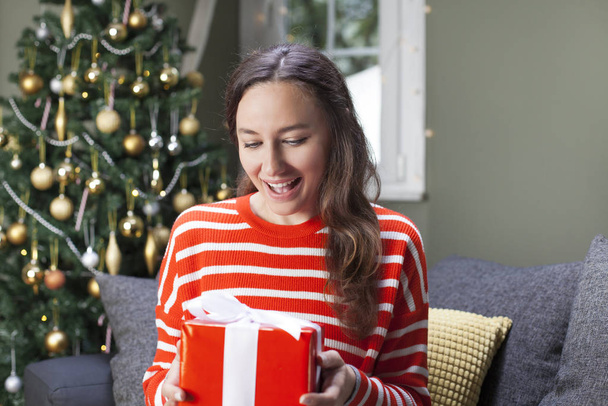 Young woman holding red gift box  - Foto, Imagen