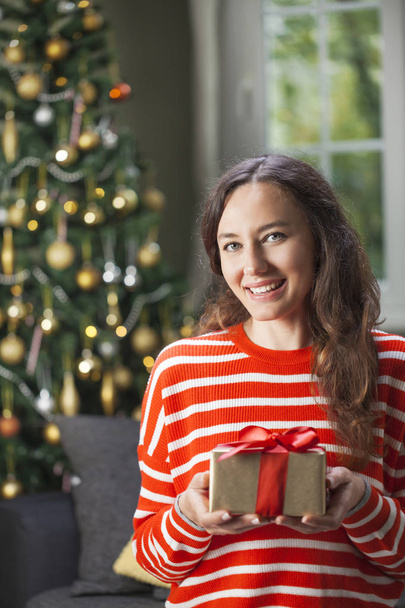 Young woman holding gift box  - Foto, Imagem
