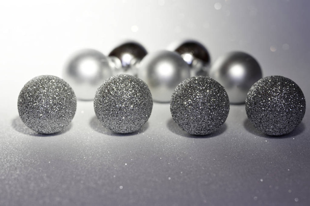 On night, Christmas-tree decorations lie on a white sparkling su - Foto, afbeelding
