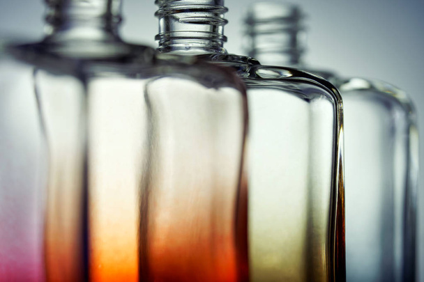 Разноцветные прозрачные бутылки для парфюмерии или напитков на свежем воздухе
 - Фото, изображение