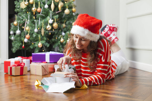Woman opening Christmas gift - Valokuva, kuva