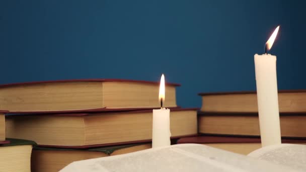 mão coloca livros na mesa com velas e um livro principal
 - Filmagem, Vídeo