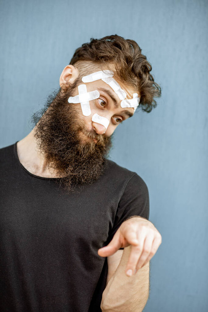 Homme avec des patchs médicaux sur le visage
 - Photo, image