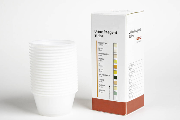 Urine Strips Box en een stapel plastic containers - Foto, afbeelding