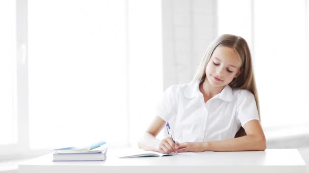 Footage of happy student girl making homework - Filmati, video